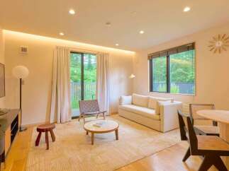 Experience modern living in this beautifully appointed living room, featuring a plush sofa and a stylish accent chair.