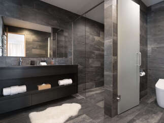 Experience modern luxury in this stunning bathroom featuring a sleek dark wood vanity with ample storage and a spacious mirror.