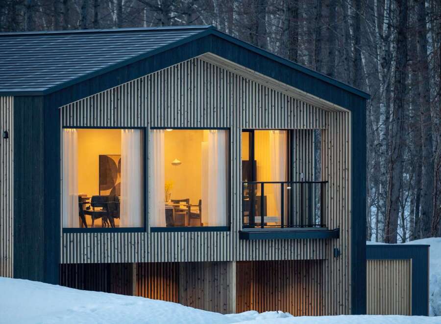 Experience modern living in this stunning home, featuring a striking architectural design with vertical wood paneling and dark blue accents.