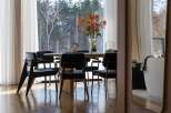 Experience elegant dining in this home, featuring a round wooden table surrounded by sleek black chairs.
