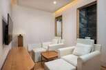 Experience ultimate relaxation in this serene living space, featuring plush white armchairs with accompanying ottomans perfect for unwinding.