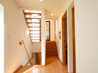 This home features a beautiful wooden staircase leading to the upper level, bathed in natural light from a nearby window.
