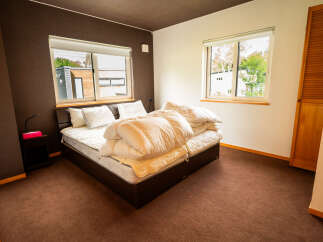 This cozy bedroom features a comfortable bed with plush white bedding, perfect for a restful night's sleep.