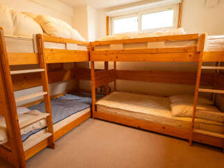 This spacious room features multiple wooden bunk beds, perfect for accommodating families or groups.
