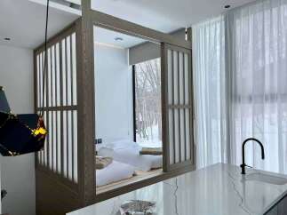 Experience serene living in this unique bedroom featuring a Japanese-inspired design with sliding shoji screens.