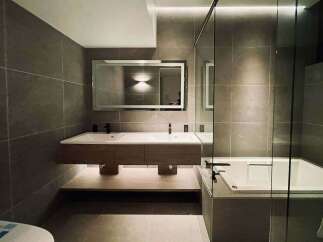 Experience modern luxury in this stunning bathroom featuring a sleek double vanity with ample storage and a freestanding bathtub perfect for relaxation.