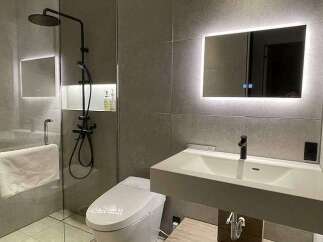 Experience modern luxury in this stunning bathroom featuring a sleek glass-enclosed shower with a rainfall showerhead and a floating vanity with an integrated sink.