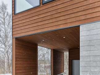 Experience modern living with this stunning property featuring a warm, wood-paneled exterior and expansive windows that invite natural light.