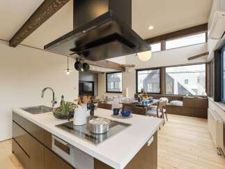 Experience modern living in this open-concept kitchen and dining area, featuring a sleek island with a built-in cooktop and ample counter space.