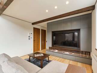 Experience modern living in this stylish living room featuring a sleek entertainment center with ample storage and a large flat-screen TV.