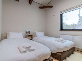 This charming bedroom features two twin beds with crisp white linens, perfect for a comfortable stay.