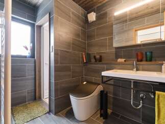 Experience modern luxury in this stunning bathroom featuring sleek, large-format grey tiles on the walls and floor.