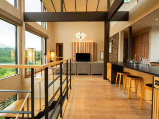 Experience modern luxury in this spacious, open-concept living area featuring a stunning double-height ceiling and expansive windows that flood the space with natural light.