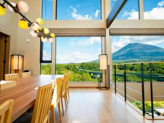 Experience breathtaking panoramic views from this stunning dining area, featuring a large wooden table and chairs perfect for gatherings.