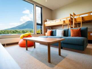 Experience breathtaking views from this spacious room, featuring a large window overlooking a serene lake and majestic mountain.
