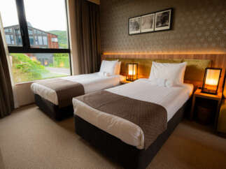 Experience comfort and style in this hotel room featuring two twin beds, perfect for solo travelers or friends.
