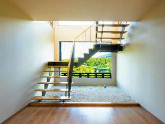 Experience modern living with this stunning staircase featuring floating wooden treads and sleek black metal supports.
