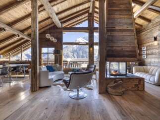 Experience luxurious mountain living in this stunning chalet, featuring a grand fireplace and breathtaking panoramic views of snow-capped peaks.