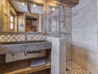 Experience rustic charm in this bathroom featuring a concrete sink and a spacious walk-in shower with modern fixtures.