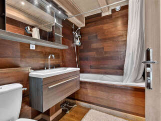 Experience rustic charm in this bathroom featuring rich wood paneling throughout.