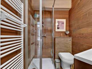 This modern bathroom features a sleek shower enclosure with glass doors and a rainfall showerhead, perfect for a spa-like experience.
