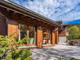Experience luxury mountain living in this stunning wooden chalet, featuring expansive decks perfect for enjoying the crisp alpine air.