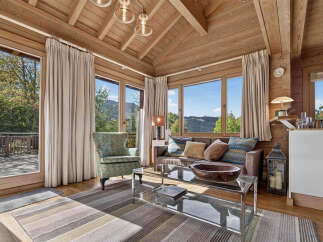 Experience breathtaking mountain views from this charming log cabin living room.