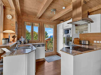 Experience rustic charm in this beautifully appointed log cabin kitchen, featuring a spacious granite countertop and modern stainless steel appliances.