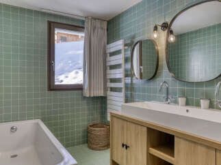 Experience luxury and comfort in this stunning bathroom, featuring a spacious bathtub and a double vanity with modern fixtures.