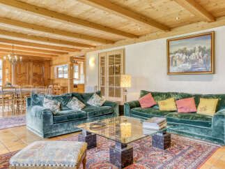 Experience rustic charm in this inviting living room, featuring plush emerald green velvet sofas perfect for relaxation.