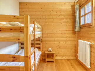 This charming room features a sturdy wooden bunk bed, perfect for families or groups.
