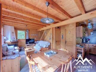 Experience cozy living in this charming wooden chalet, featuring a spacious living area with a fireplace and comfortable seating.