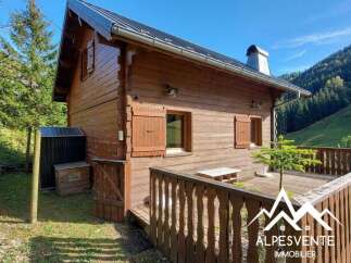 Charming wooden chalet nestled in a serene mountain landscape, perfect for a getaway.