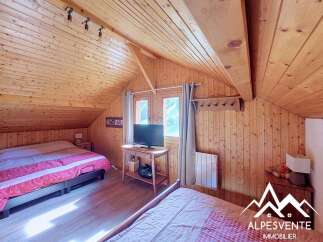 Experience cozy mountain living in this charming wooden chalet bedroom.