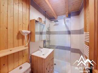 Experience comfort and convenience in this charming bathroom, featuring a modern shower with sleek tiling and a practical vanity with ample storage.