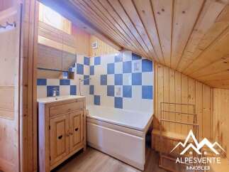 Discover this charming bathroom featuring a classic wooden vanity with a white basin and a modern chrome faucet.
