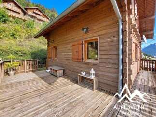 Experience mountain living in this charming wooden chalet, featuring a spacious deck perfect for enjoying the serene surroundings.