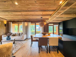 Experience luxury mountain living in this stunning open-concept living space, featuring a cozy living area with a plush sofa and a modern dining area perfect for entertaining.
