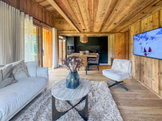Experience rustic luxury in this stunning mountain retreat, featuring a cozy living area with a plush sofa and a modern kitchen perfect for entertaining.