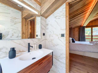 Experience modern luxury in this stunning bathroom featuring elegant marble tilework and a sleek vanity.