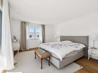 Experience serene comfort in this beautifully appointed bedroom, featuring a plush king-sized bed with elegant floral bedding.