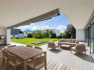 Experience luxurious outdoor living with this expansive patio, featuring a comfortable seating area and a spacious dining set perfect for entertaining.