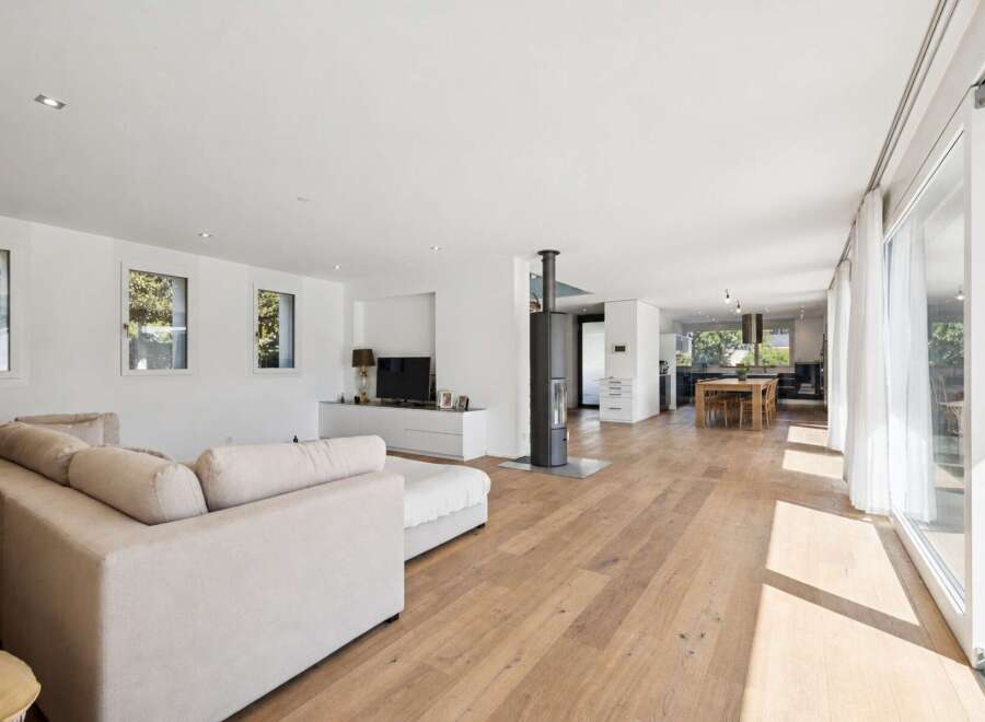 Experience modern living in this spacious open-concept home, featuring a bright living area with a comfortable sectional sofa and a sleek entertainment center.
