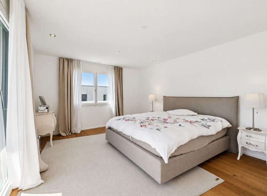 Experience comfort and style in this beautifully appointed bedroom, featuring a spacious bed with a floral duvet and a plush rug.