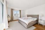 Experience comfort and style in this beautifully appointed bedroom, featuring a spacious bed with a floral duvet and a plush rug.