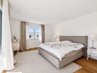 Experience comfort and style in this beautifully appointed bedroom, featuring a spacious bed with a floral duvet and a plush rug.