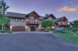 Experience luxury living in this stunning custom-built estate, featuring a grand facade with stone accents and multiple garage bays.