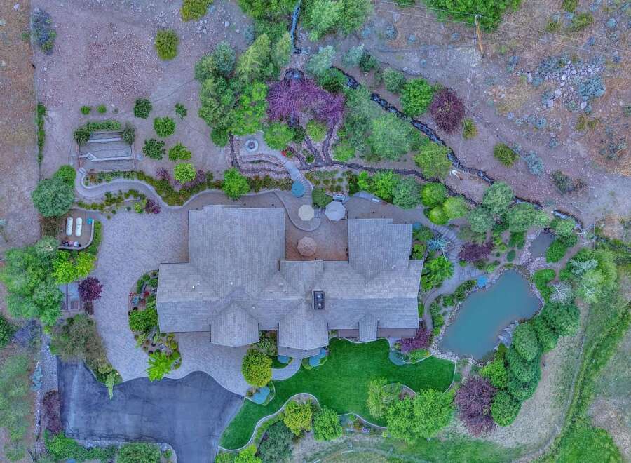 Discover this stunning estate featuring a luxurious home with a sprawling paver driveway and a beautifully manicured lawn.