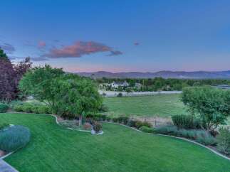 Experience serene country living with this stunning property featuring a meticulously manicured lawn and vibrant flower beds.