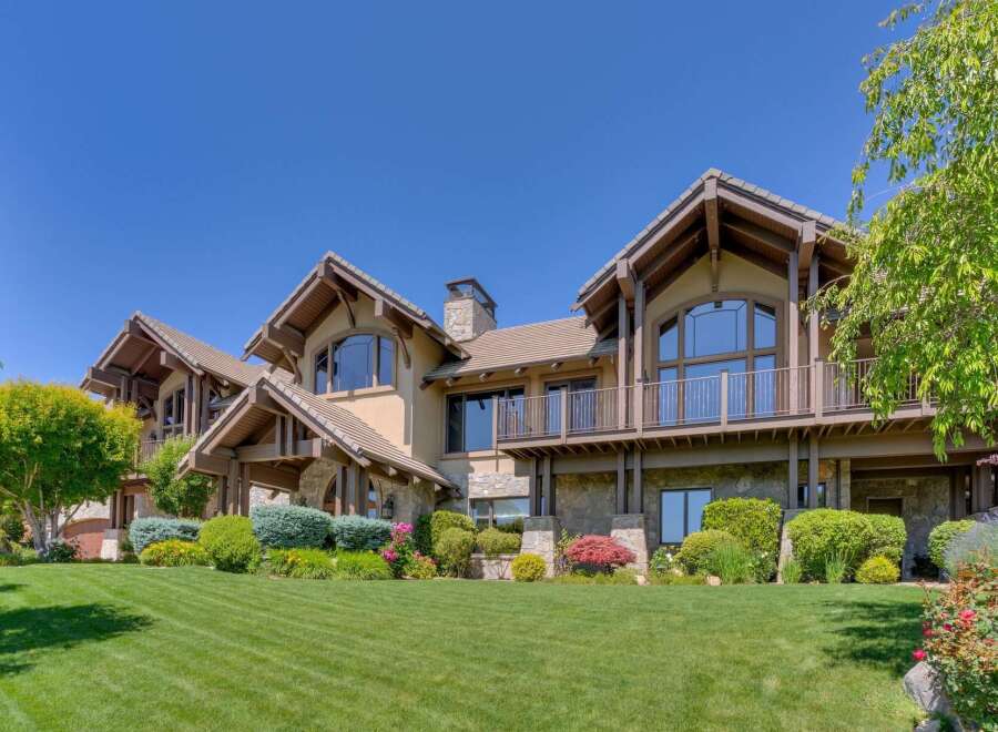 This stunning luxury home boasts a striking architectural design with a warm, inviting exterior.